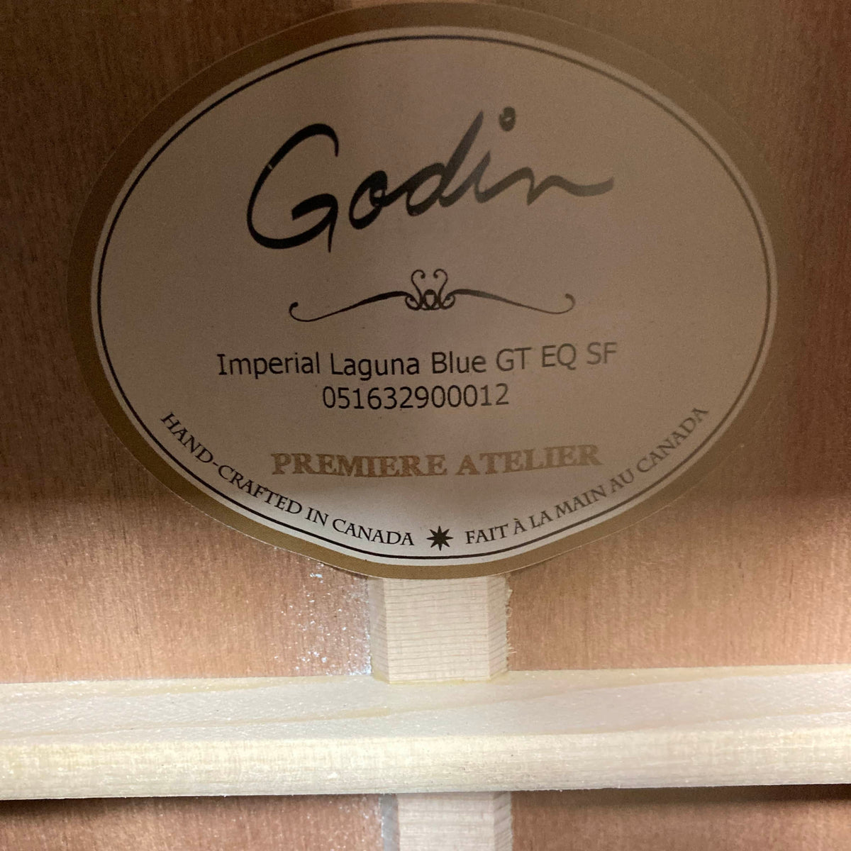 Label inside a Godin Imperial Laguna Blue GT EQ SF Acoustic Guitar w/Gigbag, showing serial number 051632900012, crafted in Canada, marked “Premiere Atelier.” Features LR Baggs Anthem system.