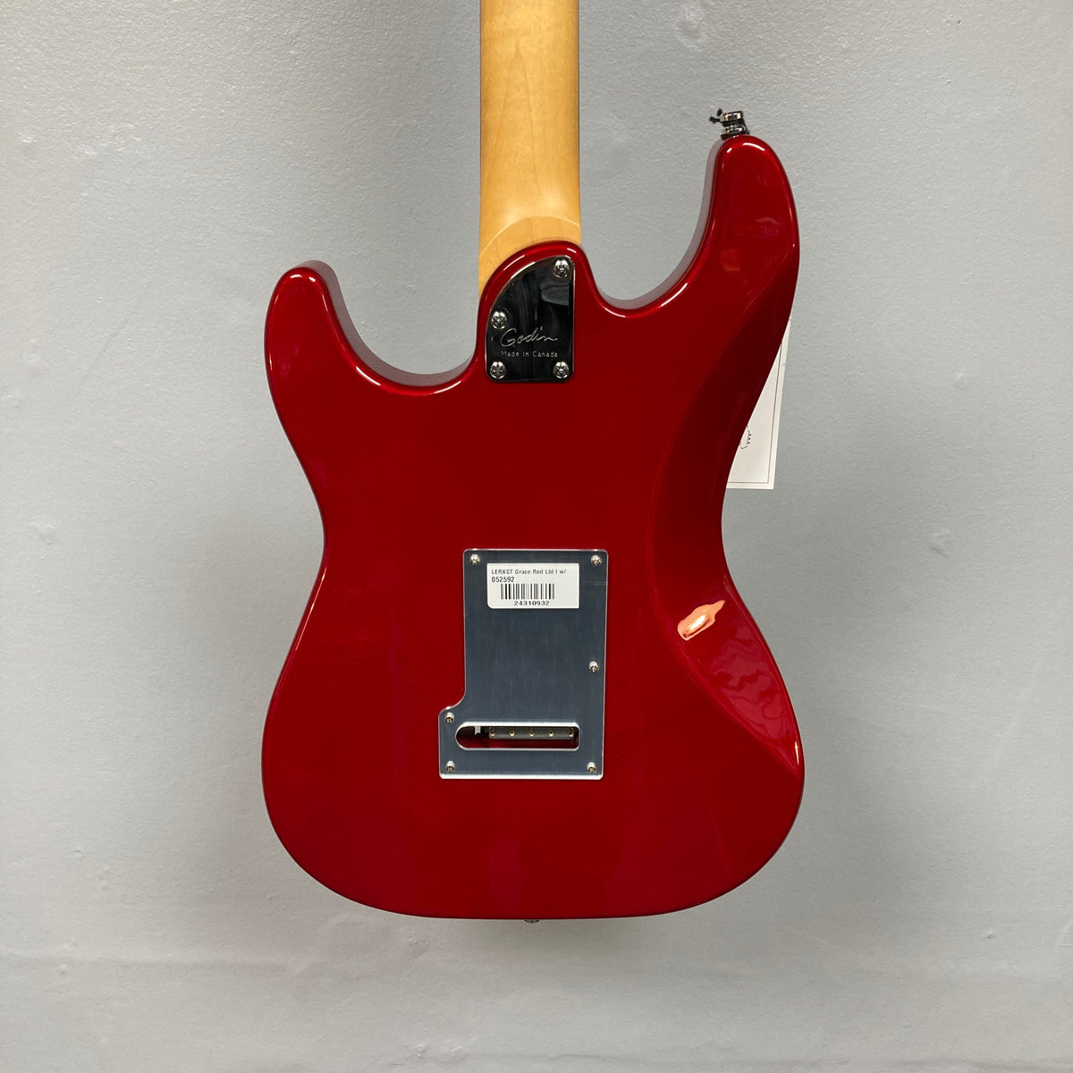 Godin LERXST Grace Red LTD I w/Floyd Rose, a sleek electric guitar displayed on a wall, showcasing its signature craftsmanship and modern features.