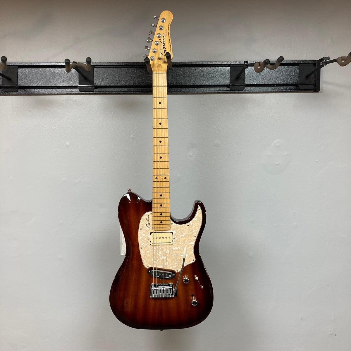 Godin Passion Custom Whiskey Burst electric guitar on display, featuring high-definition revoicer and tremolo arm customization. Comes with a gig bag.