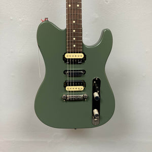 The Godin Radium Matte Green electric guitar, featuring an H-S-H pickup setup with Godin Zebra Humbuckers, two control knobs, and a rosewood fretboard, is shown against a plain light gray wall.