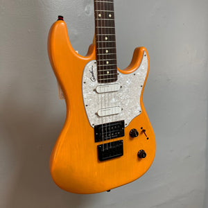 Godin Session R-HT Pro Retro Orange electric guitar with pickups and controls visible, displayed on a wall.