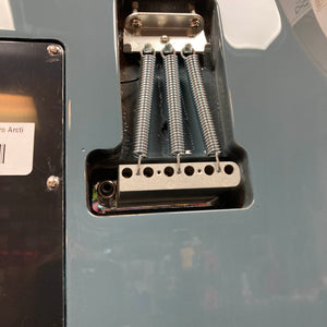 Close-up of the back of a Godin Session T-Pro with Bag by Godin, highlighting the tremolo cavity with three tension springs on the metal bridge block and part of its H-S-S pickup configuration.