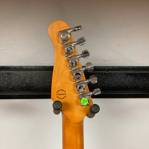 The back of a Godin Session T-Pro with Bag by Godin shows six tuning pegs, manufacturer stamps, and a green QC sticker as it rests on a wall-mounted holder—perfect alongside its versatile H-S-S pickup layout.