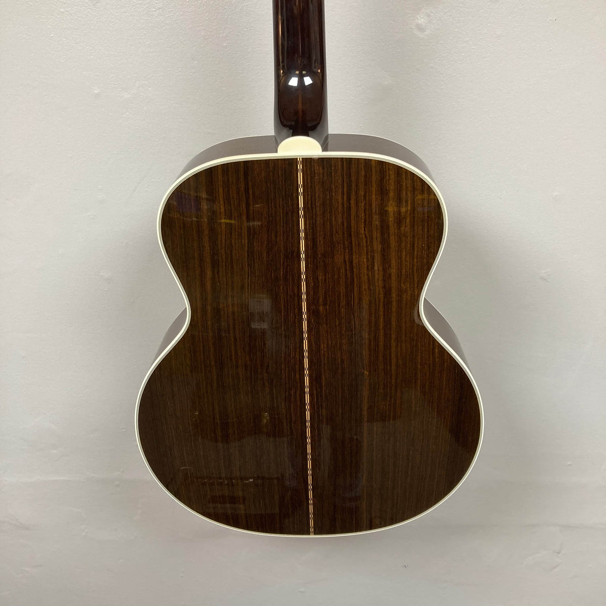 Rear view of a Guild USA F-512 w/OHSC 2005 Circa jumbo 12-string acoustic guitar featuring a dark wood finish, cream edge binding, and a decorative center strip.
