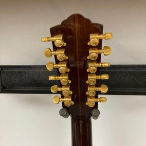 Close-up of the back of a Guild USA F-512 w/OHSC 2005 Circa 12-string guitar headstock, featuring six pairs of gold tuners against a plain background.