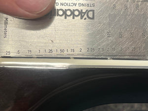 A metal ruler marked in mm and inches measures the width of a Guild USA F-512 w/OHSC 2005 Circa by Guild, showing it's slightly over 2 inches. A hand holds the ruler in place.