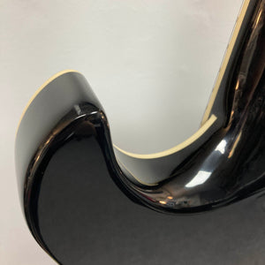 Close-up of a Hagstrom Fantomen Custom Black w/case electric guitar body, featuring its glossy black finish, curved cutaway edge, and cream binding against a plain background.