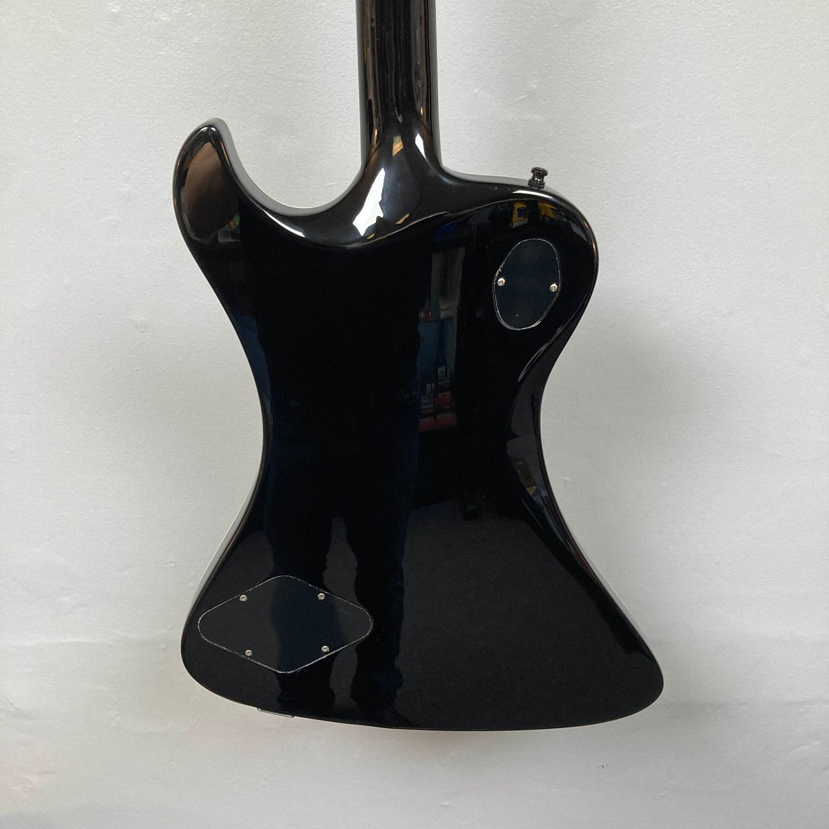 The back of a Hagstrom Fantomen Custom Black electric guitar with two access panels, photographed against a plain white wall.