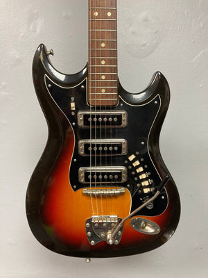 Hagstrom III 1960s Sunburst Electric Guitar on a stand, showcasing its vintage craftsmanship, visible strings, and neck details, includes original case.