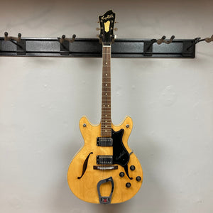 Hagstrom Viking 1968 Natural guitar hanging on a hook, showcasing its vintage design and distinct body shape.