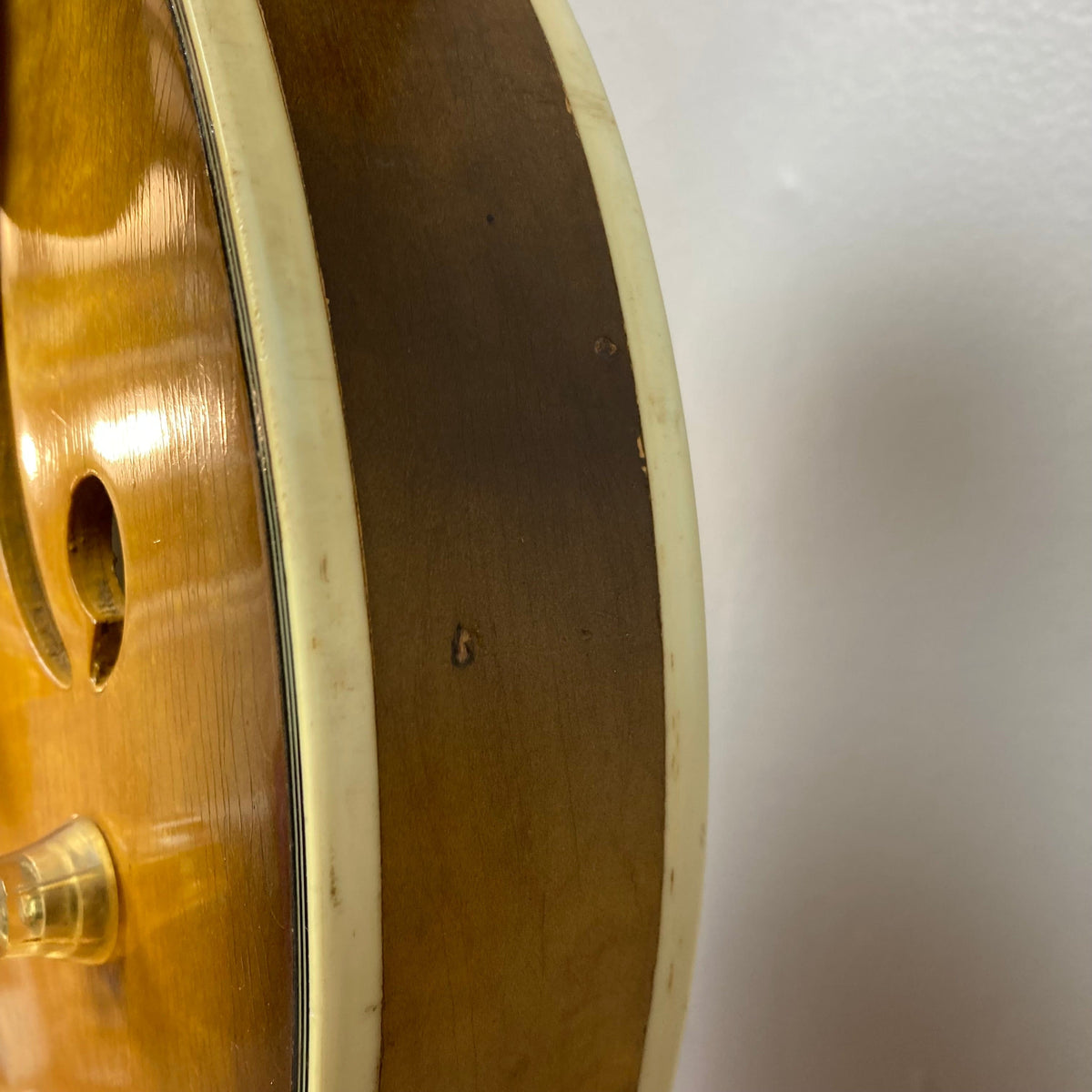 Close-up of the Harmony H-75 1960s Sunburst guitar, highlighting its stunning sunburst finish and detailed craftsmanship. Minor finish blemishes visible.