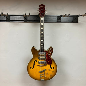 Harmony H-75 1960s Sunburst electric guitar on display hook, showcasing its vintage sunburst finish and classic design.