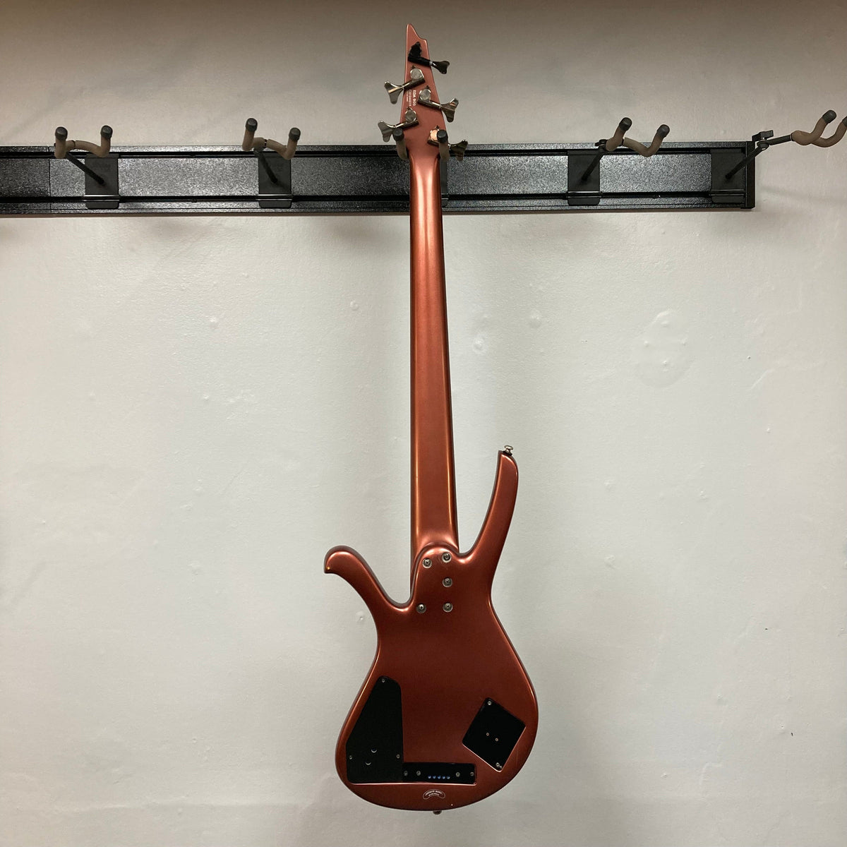 Ibanez Ergodyne Eda 905 5-string Bass displayed on a hook, highlighting its innovative design and professional setup.