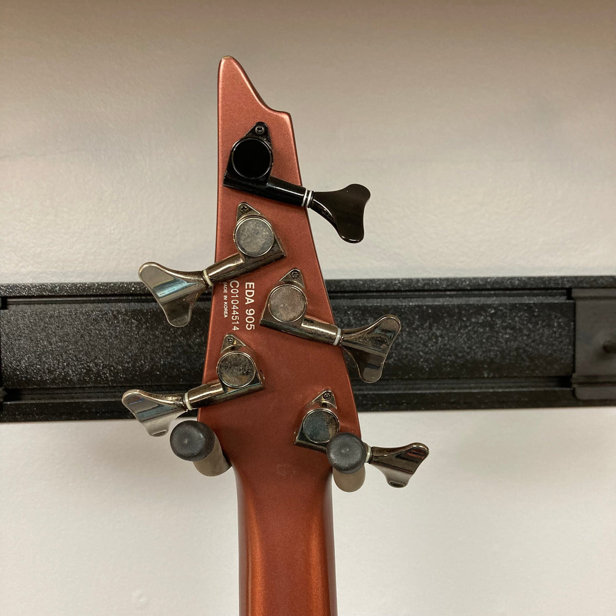 Ibanez Ergodyne Eda 905 5-string bass guitar head close-up, showcasing multiple tuning pegs and reversed tuning machines.