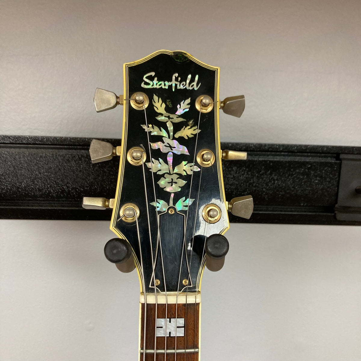 Ibanez Starfield hollow body guitar with a sticker, showcasing a classic design and a single humbucker neck pickup.