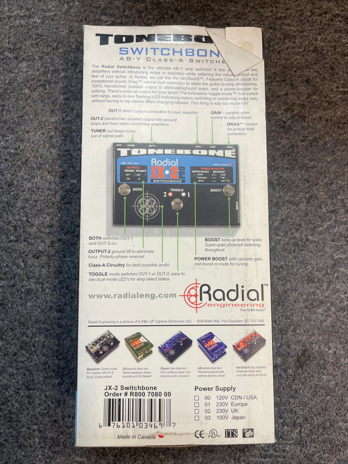 Back of a preowned Radial Engineering Tonebone Switchbone JX-2 AB-Y Class-A Switcher, showing product details, specs, and diagrams for its AB-Y amp switching and transformer-isolated output on a gray surface.