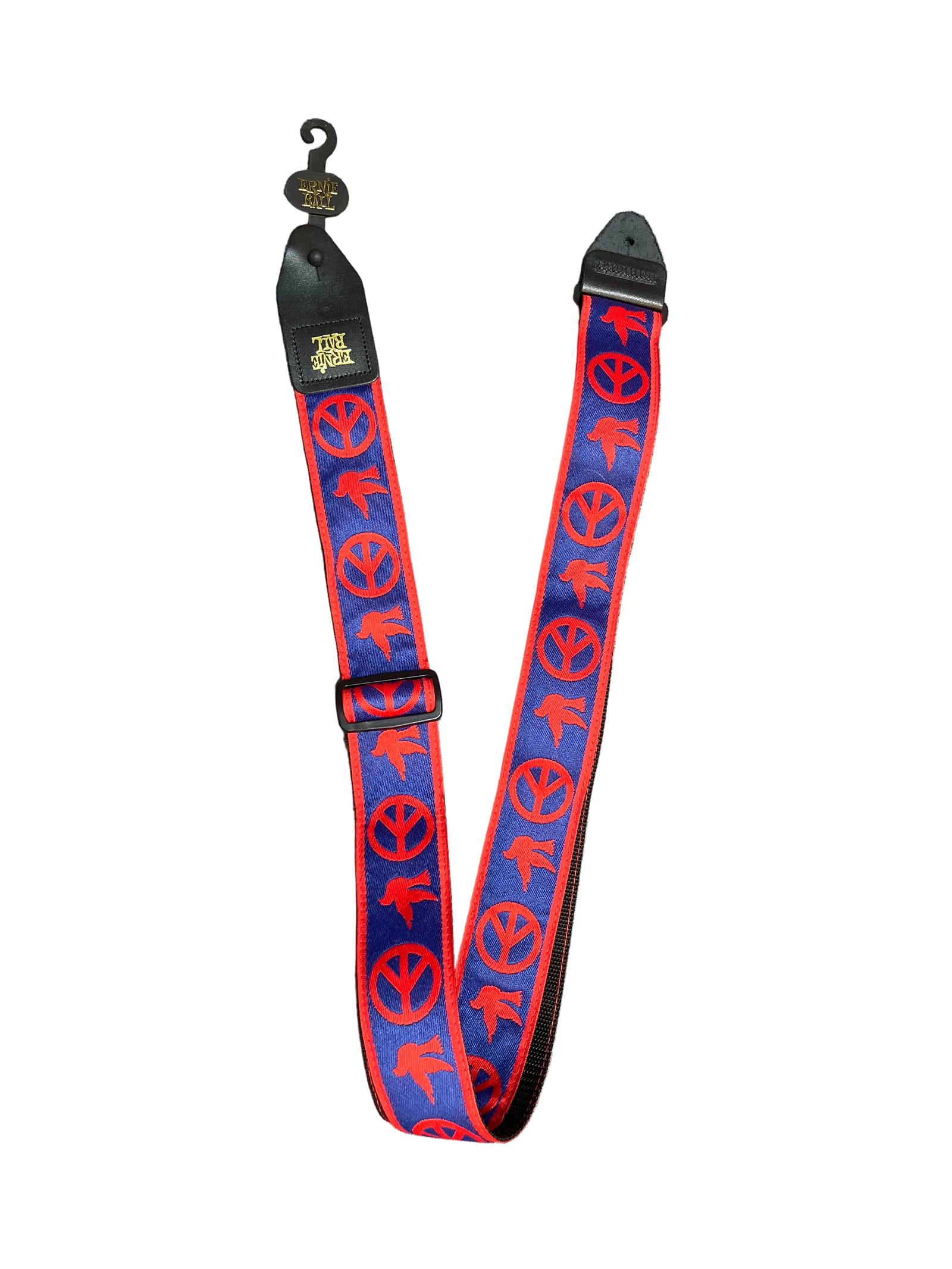 The Ernie Ball Guitar Strap - Peace & Dove by Ernie Ball features red peace signs and doves on a blue background, black leather ends, and an adjustable buckle.