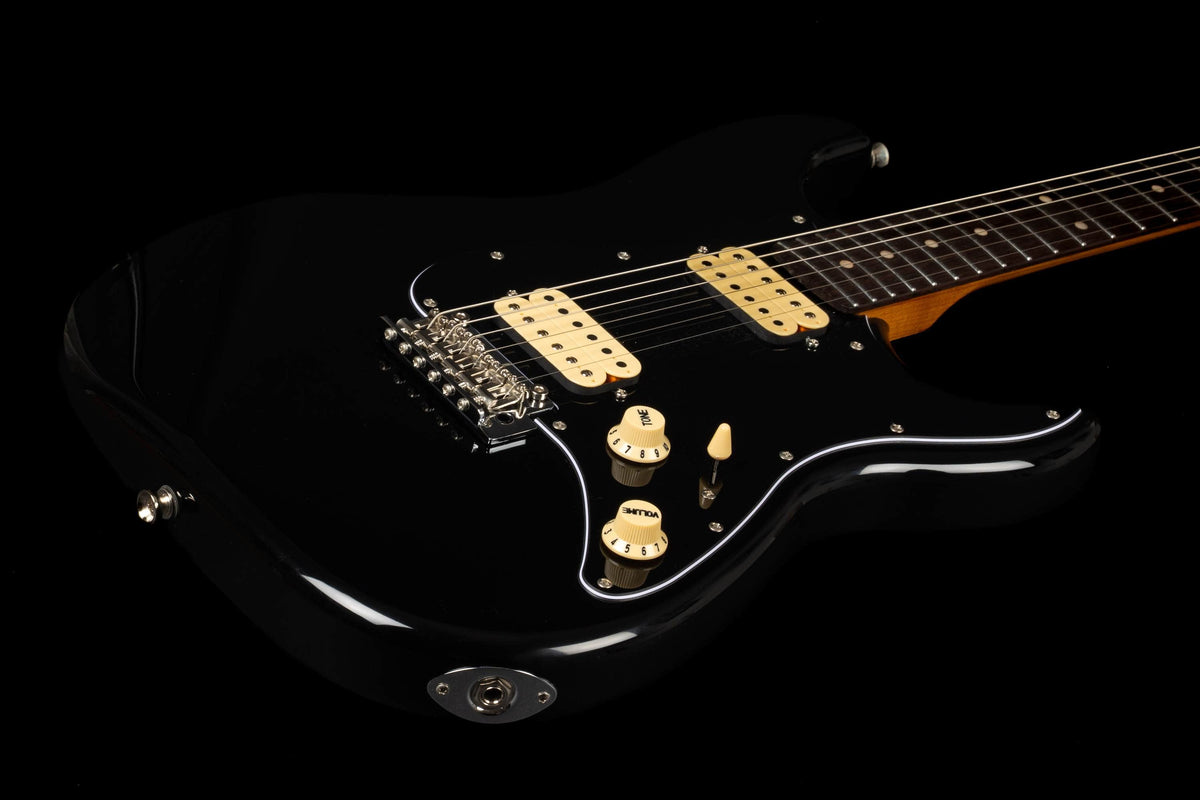 The Jet JS-400 BKR H by Jet is a black electric guitar distinguished by its cream-colored pickups, control knobs, and chrome bridge, making it stand out against a black background. Equipped with dual ceramic HH pickups, this guitar offers modern playability designed for both style and performance.