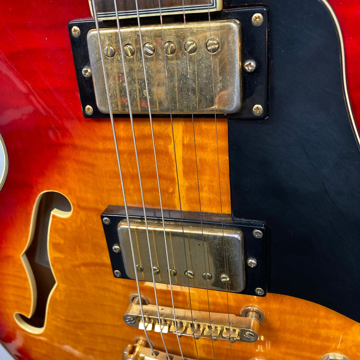 Johnson JH-250-C Semi Hollow Cherry Burst guitar close-up, highlighting its strings and craftsmanship, ideal for music enthusiasts and players.