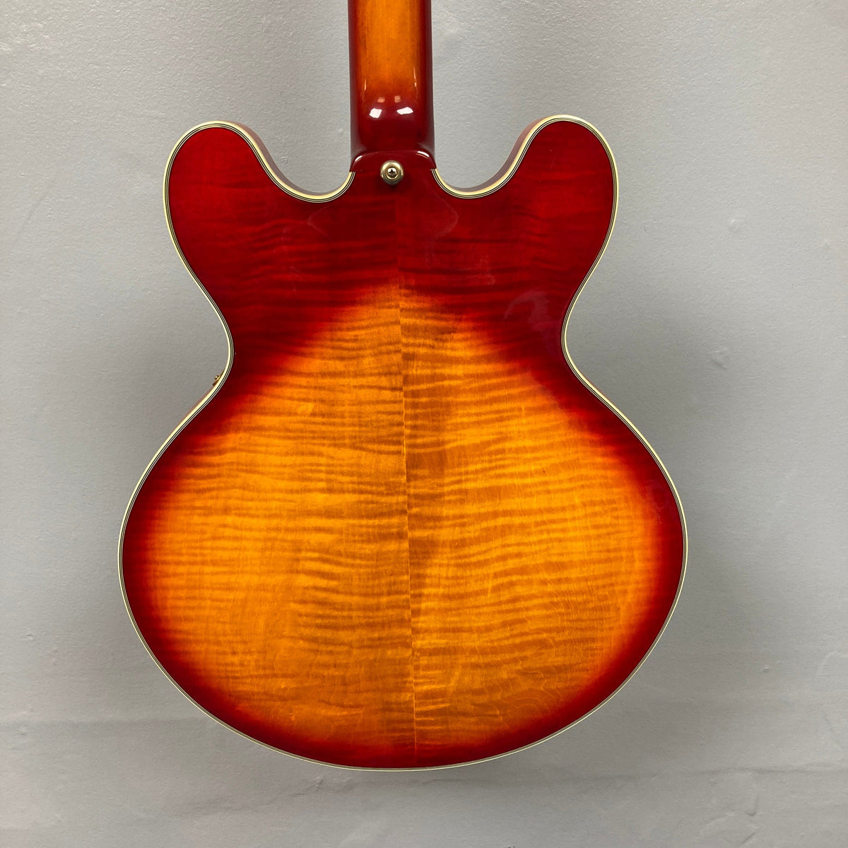 Close-up of a Johnson JH-250-C Semi Hollow Cherry Burst guitar, highlighting its strings and craftsmanship, ideal for enthusiasts at Guitars on Main.