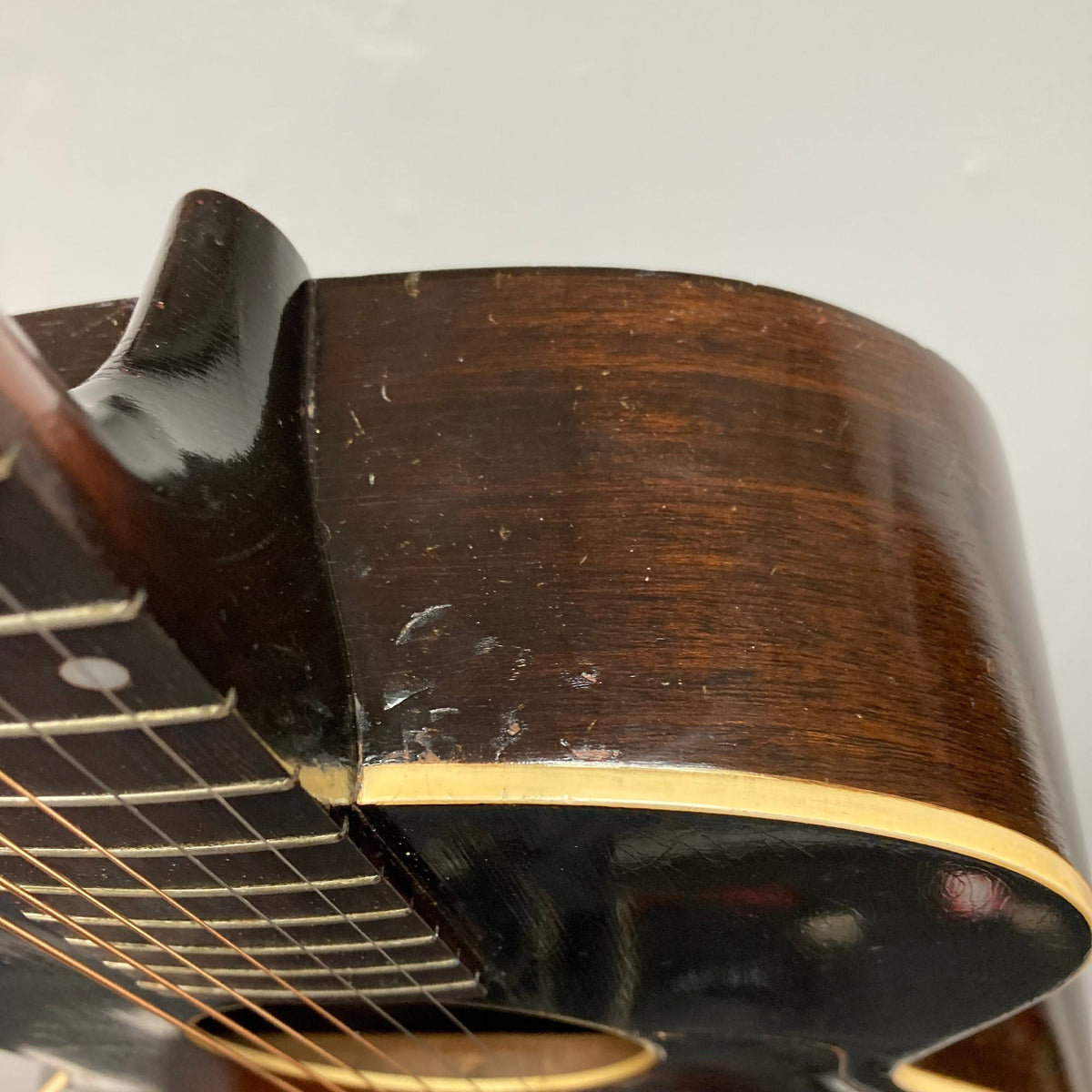 Close-up of the vintage Kalamazoo KG-14 Sunburst guitar from the 1930s, showcasing its restored neck joint and bridge.