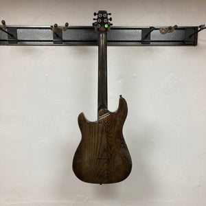 KLOS Apollo Pro Electric Guitar Dark Brown on a rack, showcasing its advanced carbon fiber neck and resonant Ash body.