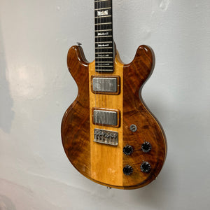 Kramer 650G Deluxe 1986 electric guitar, brown and black, close-up of strings and dials, iconic '80s rock design.