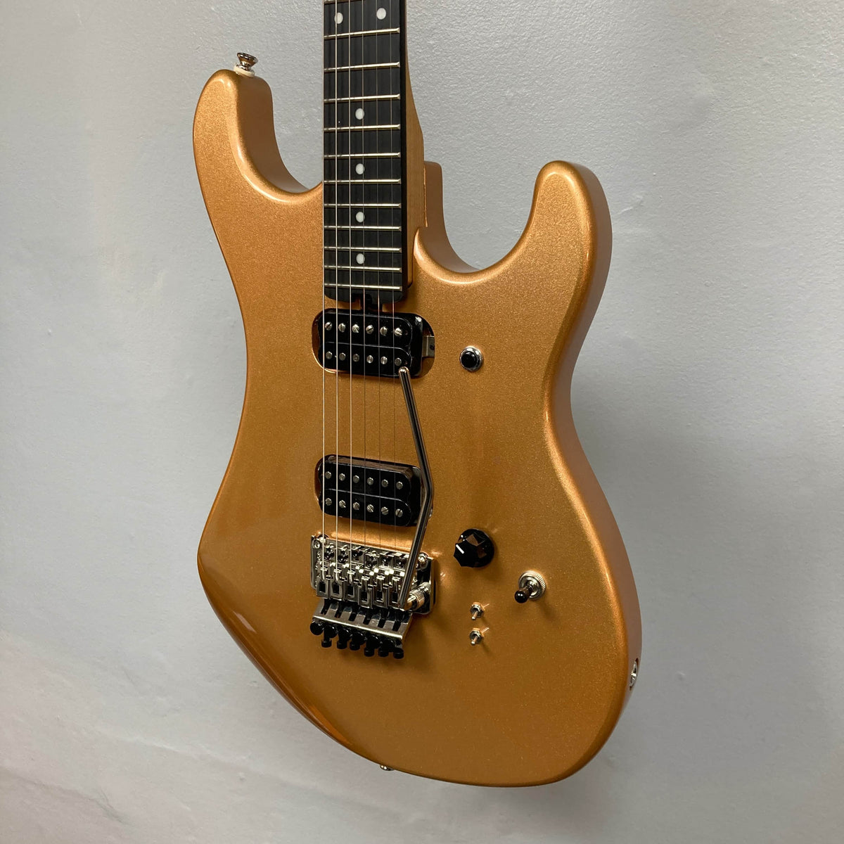 A Kramer 84 HH Killswitch electric guitar in Smoked Almond Metallic with a dark fretboard, dual humbuckers, Floyd Rose tremolo, and control knobs is shown against a plain light gray background. Gigbag included.
