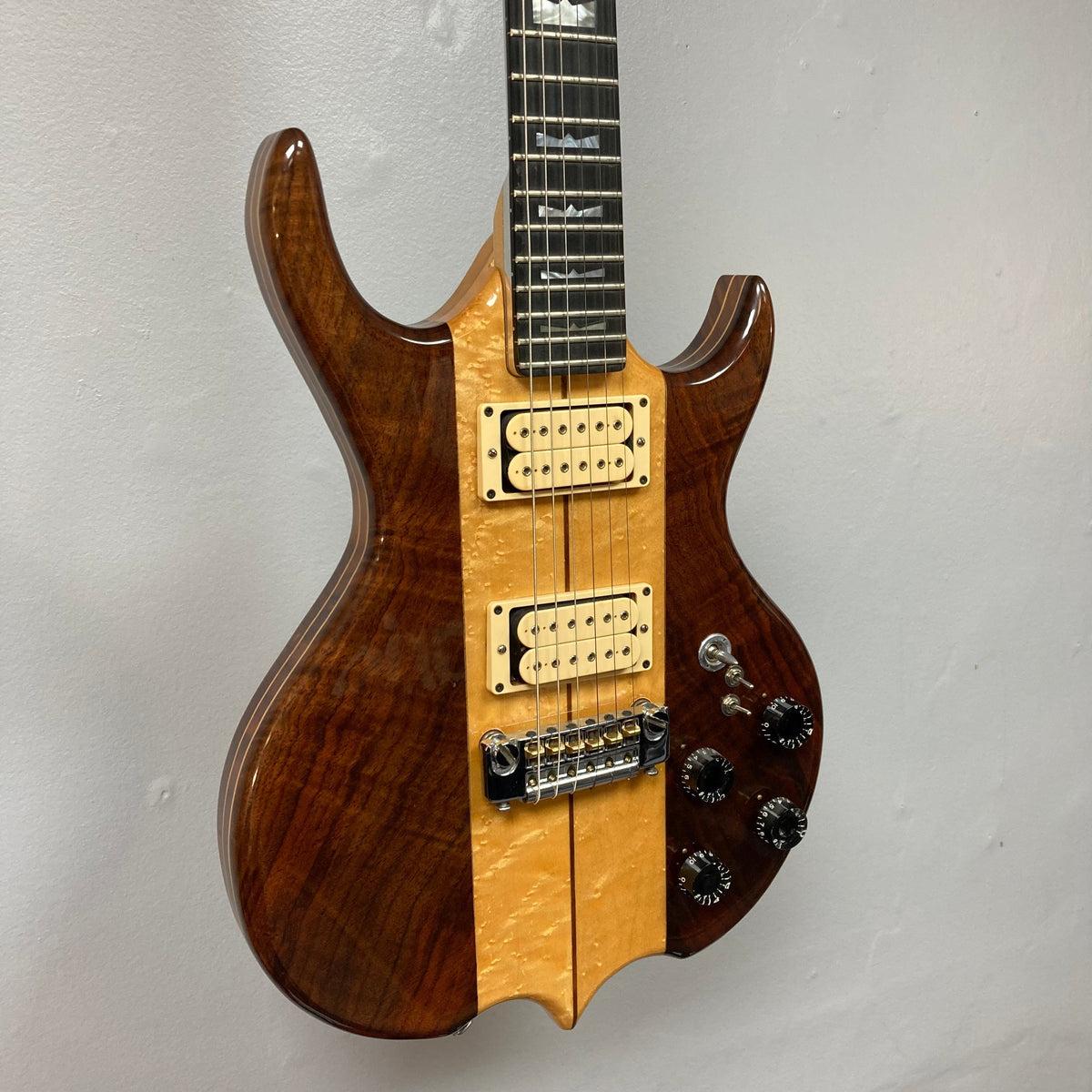 Kramer DMZ 6000-G Natural electric guitar, close-up showing maple body, aluminum neck with wooden inserts, Ebonal fingerboard, and two DiMarzio humbucker pickups.