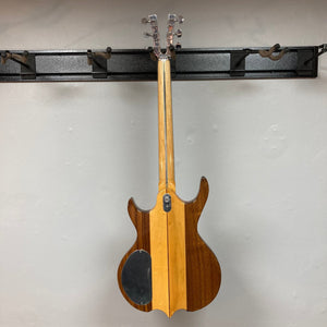 Kramer DMZ 6000-G Natural guitar with aluminum neck, wooden inlay, and two DiMarzio humbucker pickups, displayed hanging on a wall.