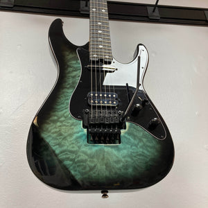Electric guitar with a black and green patterned body on a light gray background