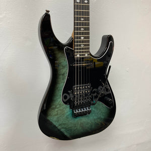 Black and green electric guitar on a light gray background