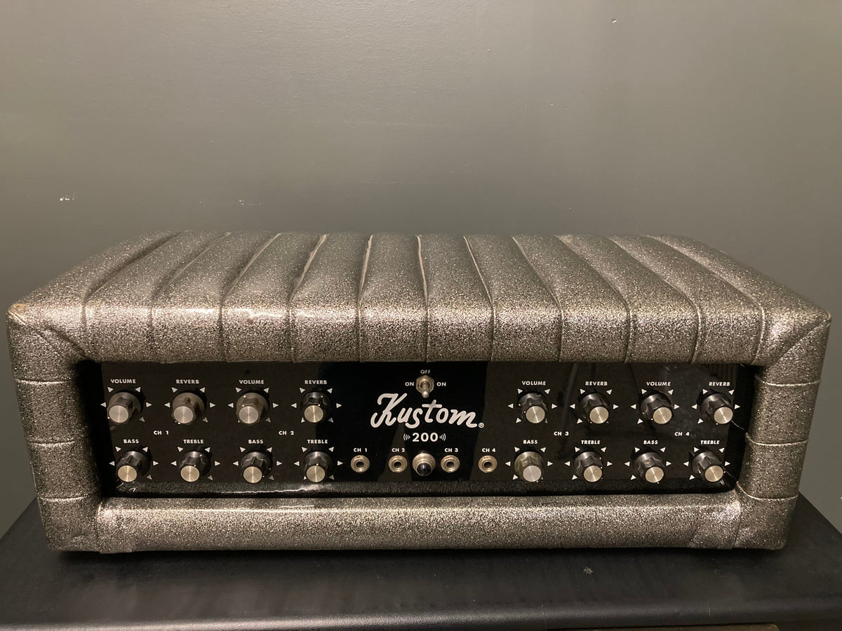 Kustom 200 1970&#39;s Champagne Silver Sparkle Tuck And Roll Tolex Amp Head, featuring a sleek silver and black design, shown in close-up detail.