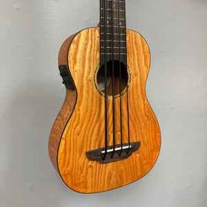 Close-up of a Luna Bari-Bass Quilt Ash Top Bass Ukulele with preamp, showcasing intricate ash body and strings.