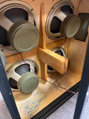 The image shows the interior of a 1969 Marshall 4x12 Cabinet with matching Celestion T1281 Greenbacks, wiring, a wooden support beam, and a floor panel featuring a diagram marked "SCHEMATIC.