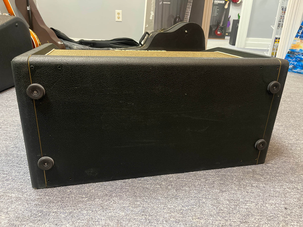 The underside of a 1969 Marshall 4x12 Cabinet with Matching Celestion T1281 Greenbacks, featuring four rubber feet, is shown resting on a gray carpeted floor.
