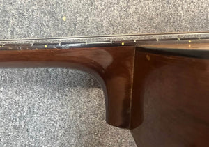 Close-up of the neck joint on a Martin 00-18G Classical Guitar (c. 1961–1962) by Martin, showing some wood wear; the nylon string guitar rests on a gray carpet.