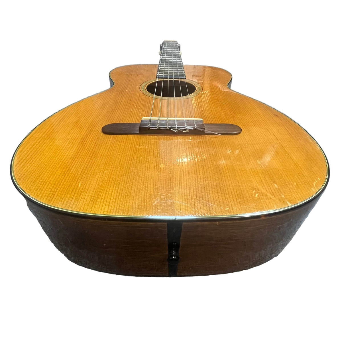 Photographed from the body end, this vintage Martin 00-18G Classical Guitar (c. 1961–1962) displays its nylon strings, sound hole, and wooden finish against a white background.