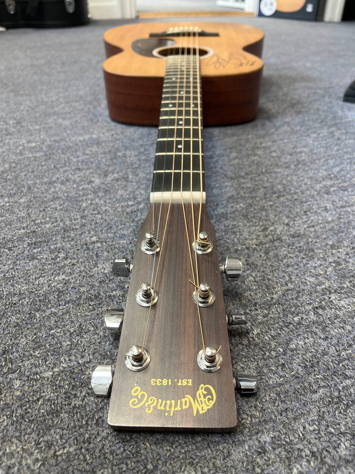 A Martin 00X1AE Acoustic-Electric Guitar signed by Richie Kotzen, viewed from the headstock down the neck.