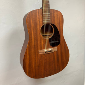 Martin D-15M acoustic guitar hanging on a wall, showcasing its solid mahogany construction and traditional dreadnought shape.