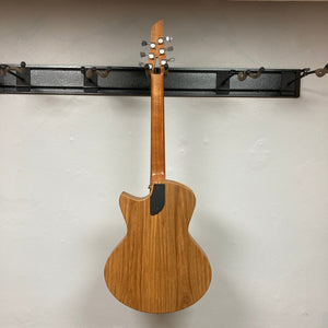 Murray Kuun Coupe Natural Acoustic Guitar displayed on a wall, highlighting its elegant wooden design and craftsmanship, ideal for music enthusiasts.