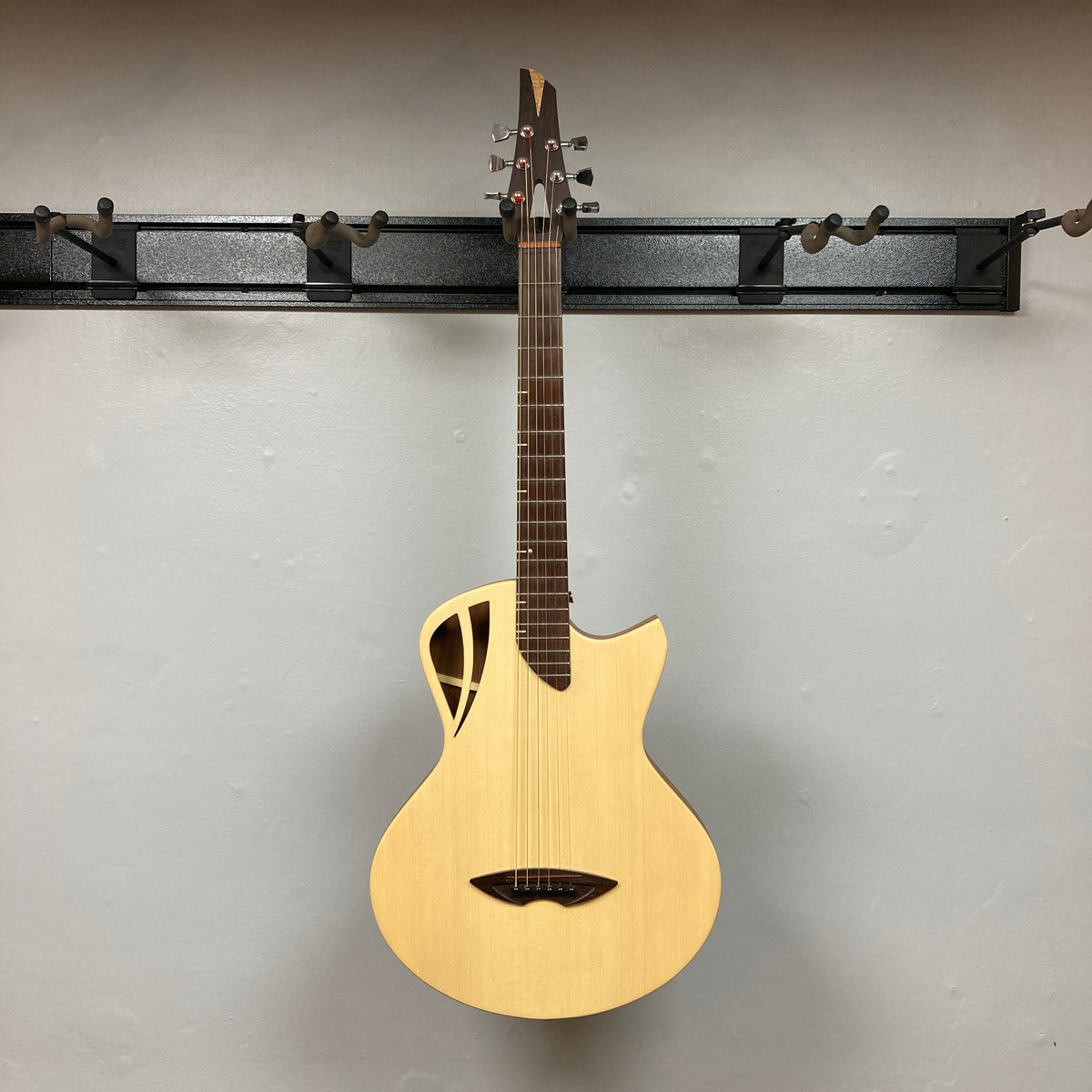 Murray Kuun Coupe Natural Acoustic Guitar displayed on a wall, highlighting its elegant design and craftsmanship, ideal for music enthusiasts and collectors.