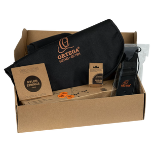 An Ortega Pickers Pack 3/4 Classical Guitar, Gloss, Bag inside a cardboard box, including a black guitar bag, strings, a clip-on tuner, three picks, and a black guitar strap.