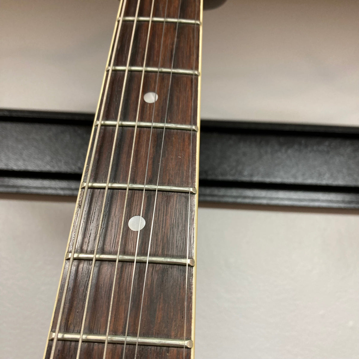 Close-up of a Palmer Semi-hollow 1970-80s ES-335 guitar neck, showcasing vintage craftsmanship and dual humbucker pickups, highlighting the instrument&#39;s quality and playability.