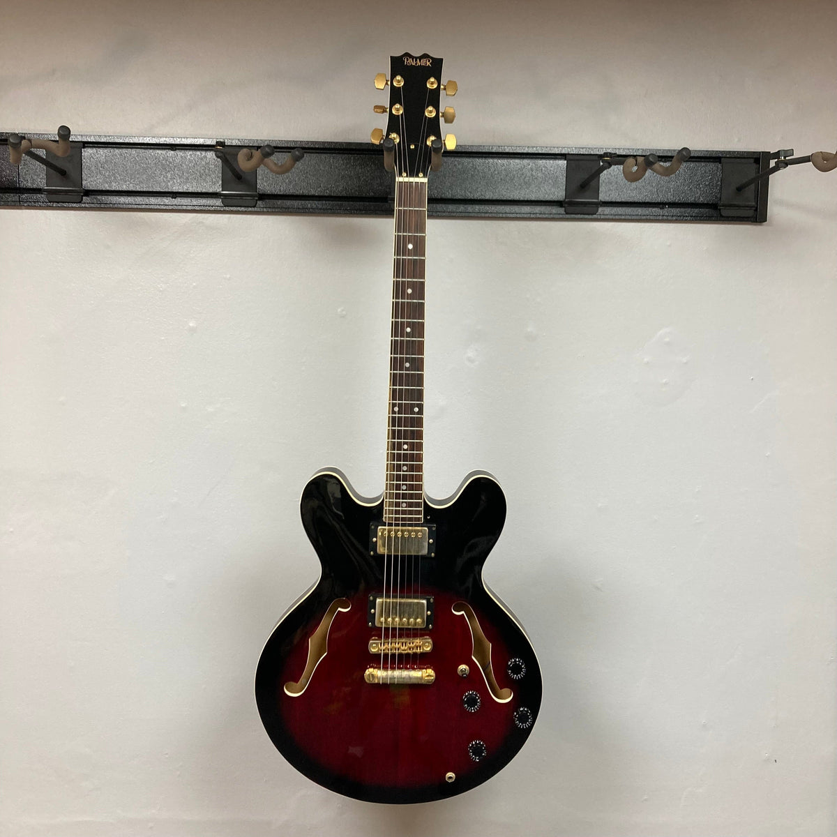 Palmer semi-hollow 1970-80s ES-335 electric guitar displayed on a wall, showcasing its vintage craftsmanship and dual humbucker pickups.