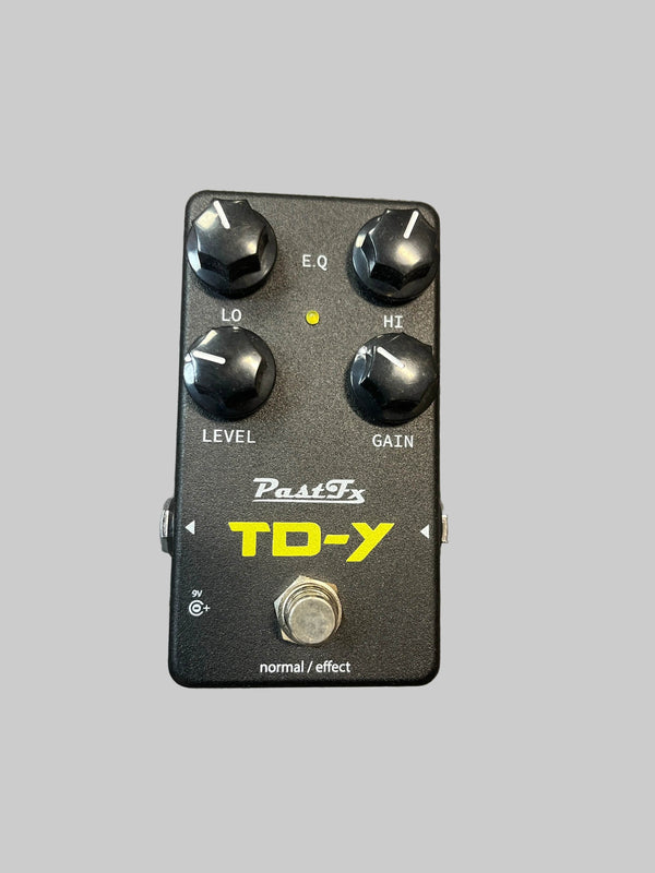 A preowned PastFx TD-Y Overdrive Pedal by PastFx is displayed on a textured gray surface. This black boutique unit features four control knobs labeled LO, HI, LEVEL, and GAIN, along with a footswitch. Renowned for its studio-quality tone and touch-sensitive overdrive, it’s an ideal choice for discerning guitarists.