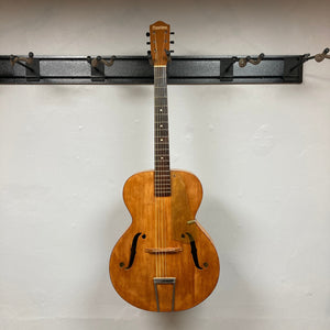 Playtime by Harmony Vintage Archtop Guitar 1940's hanging on a hook, showcasing its classic design and well-preserved condition, ideal for musicians and collectors.