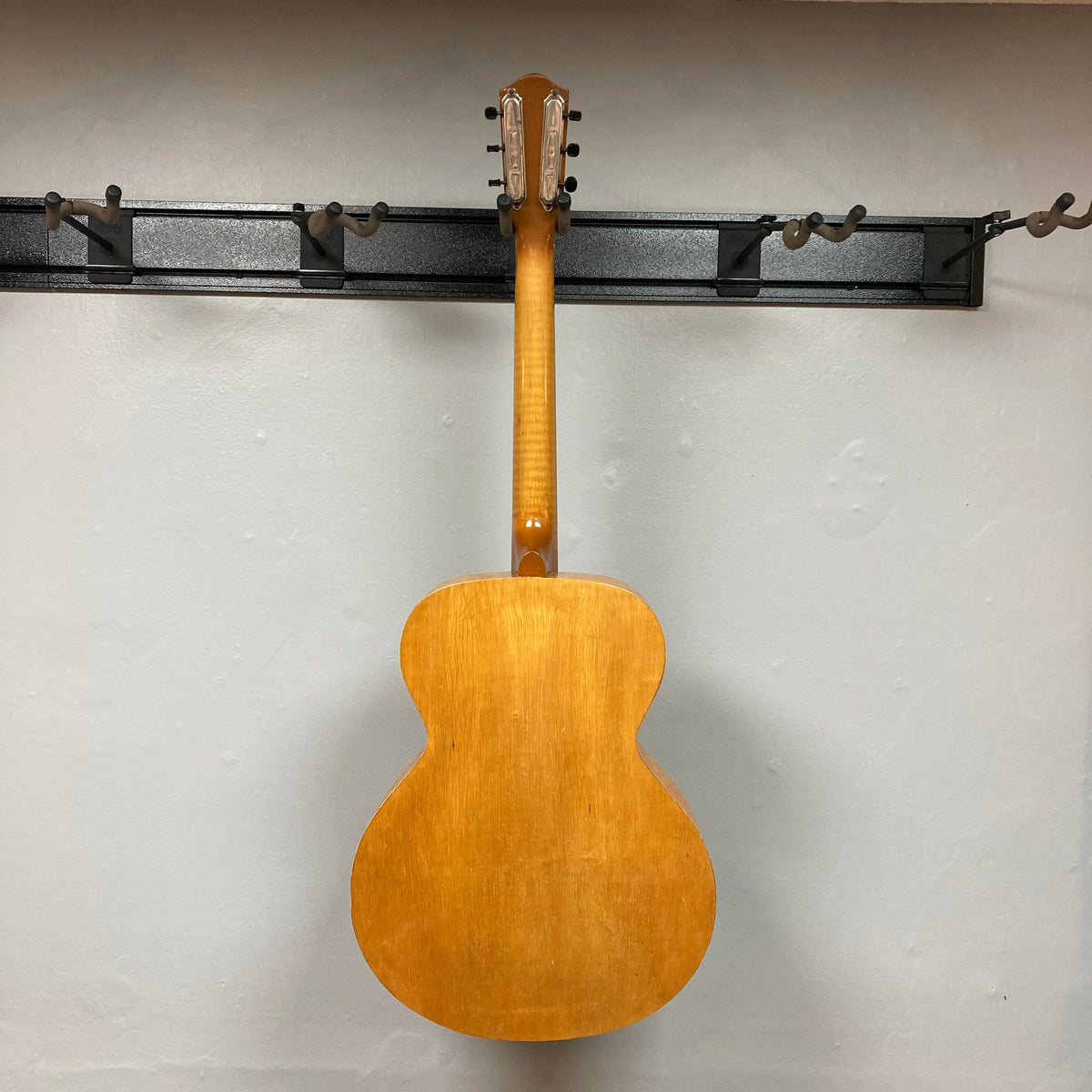 Playtime by Harmony Vintage Archtop Guitar 1940&#39;s displayed on a wall, showcasing its classic design suitable for musicians and collectors.