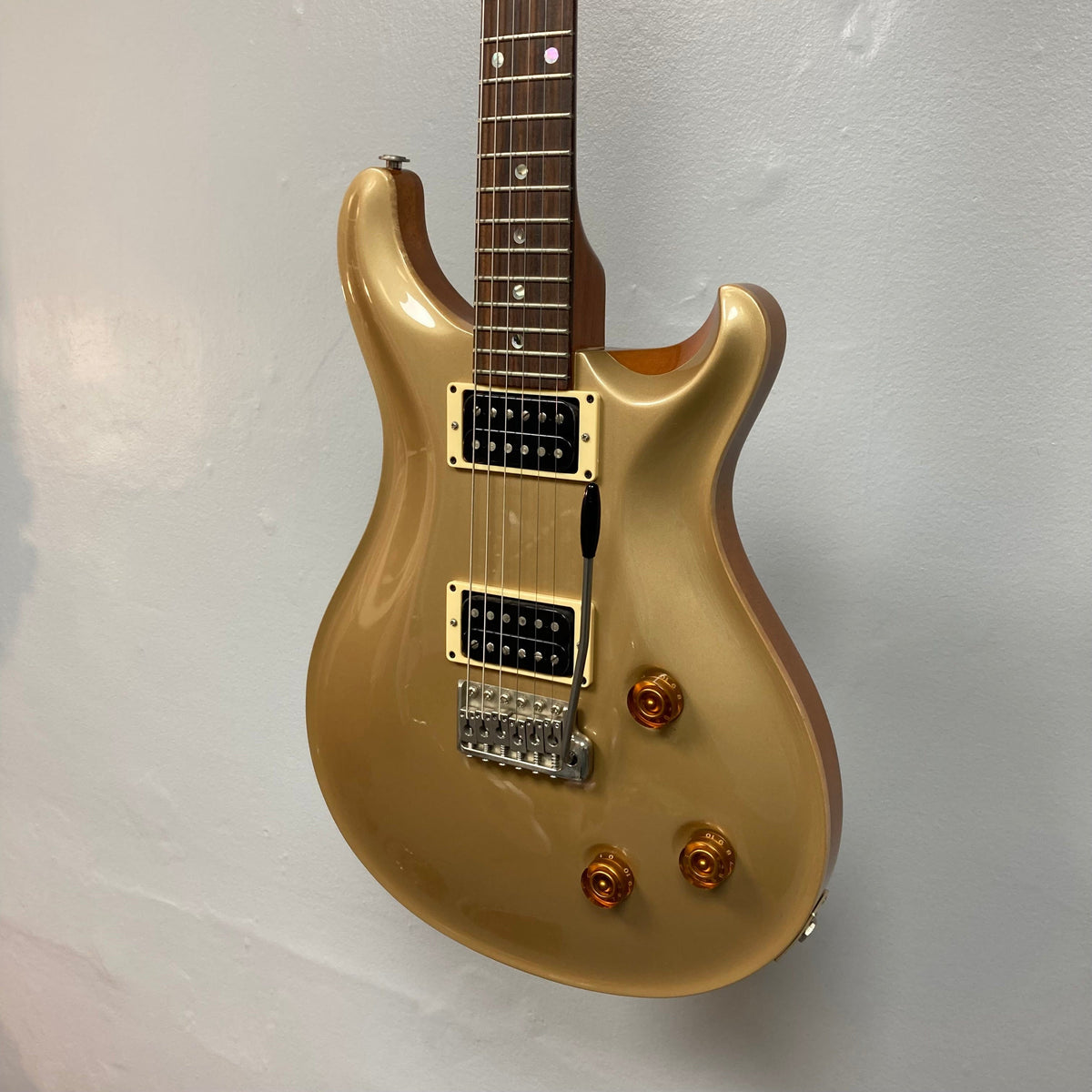 PRS 1996 Gold Top electric guitar on display, showcasing its lustrous gold finish and intricate details, including dials and bridge. Comes with original hard case.