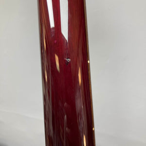 Close-up of a glossy red PRS Custom 24 Angry Larry 2011 electric guitar surface by PRS, showing a visible chip or dent in the finish, set against a neutral background.